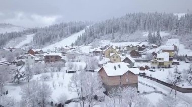 Karla kaplı dağlar köyde üzerinde uçuş. Açık soğuk hava
