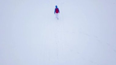 Uçuş bir dağın tepesine yürüyüş yalnız turist kız yüzünden karla kaplı. Rahatsız düşmanca kış hava.