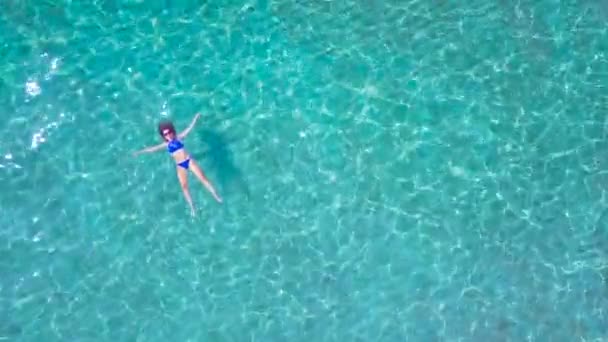 Расслабленная красивая девушка лежит на спине в летнее море — стоковое видео