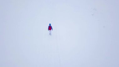 Uçuş bir dağın tepesine yürüyüş yalnız turist kız yüzünden karla kaplı. Karlı soğuk havalarda