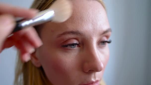 化妆艺术家应用粉末, 使面部形状的矫正女孩 — 图库视频影像