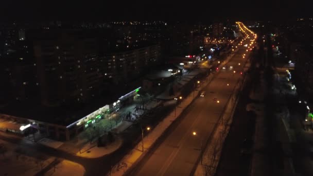 Blick von der Höhe auf die beleuchteten vielbefahrenen Straßen und nächtlichen, mehrstöckigen Häuser. Ukraine — Stockvideo