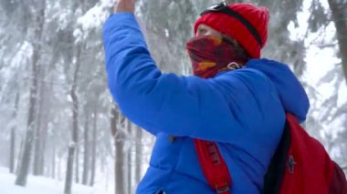 Yalnız turist kız kış karla kaplı iğne yapraklı bir ormanda dağlarda yürüyüş ve doğa fotoğrafı Smartphone'da alır. Soğuk hava