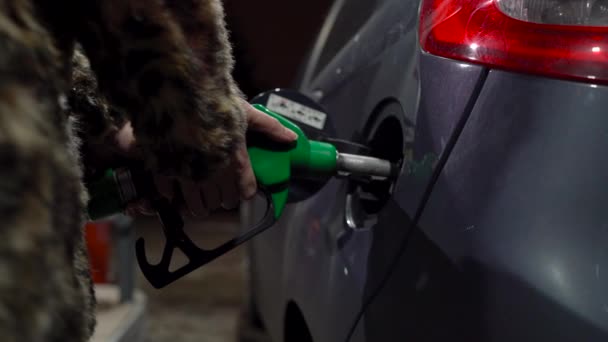 Mulher enche gasolina em seu carro em um posto de gasolina no inverno — Vídeo de Stock