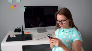 Yaratıcı ofiste bir kahve molası sırasında telefonda konuşurken rahat grafik tasarımcı