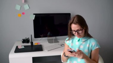 Yaratıcı ofiste bir kahve molası sırasında telefonda konuşurken rahat grafik tasarımcı