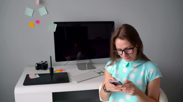 Designer gráfico casual falando ao telefone durante uma pausa para café no escritório criativo — Vídeo de Stock