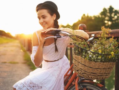 Güneş çiçekleri ile onun bisiklet üzerinde oturan genç güzel kadın