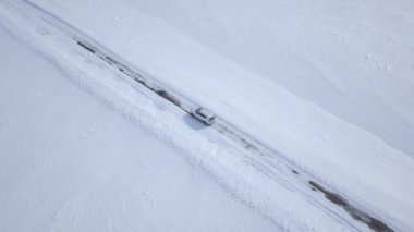 Karla kaplı alanlar arasında kış orman yolu sürüş araba havadan görünümü