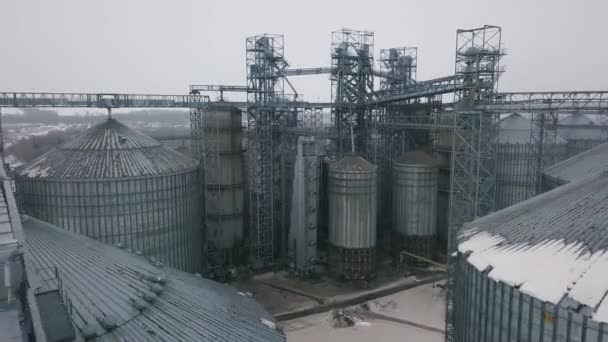 Vlucht onder graanschuren en liften of olie-opslag op winter achtergrond — Stockvideo