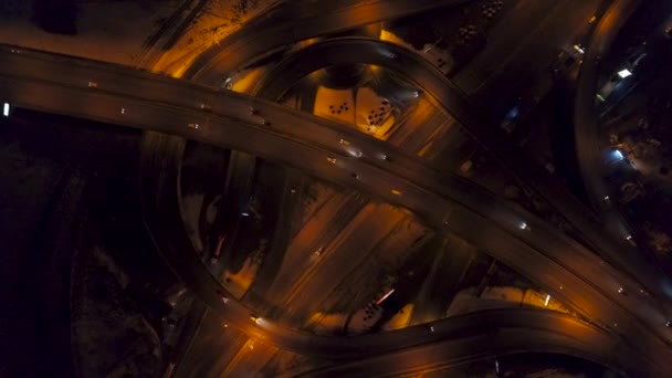 Vista aérea vertical de arriba hacia abajo del tráfico en el intercambio de la autopista en la noche, velocidad rápida — Vídeo de stock