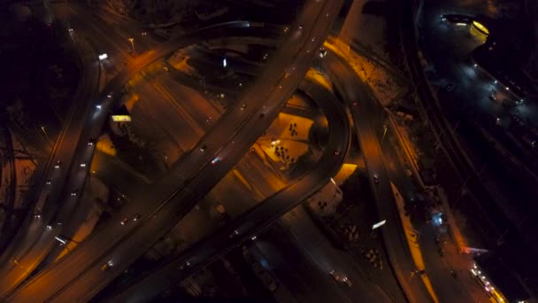 Verticale top-down luchtfoto van het verkeer op de snelweg interchange nachts — Stockvideo