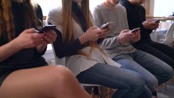 Grupp människor använder mobiltelefoner på ett kafé i stället för att kommunicera med varandra — Stockvideo