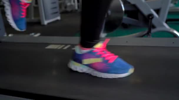 Spor salonunda koşu bandı üzerinde çalışan kadın — Stok video