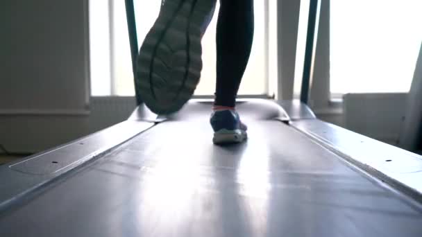 Vrouw draait op loopband in de sportschool — Stockvideo