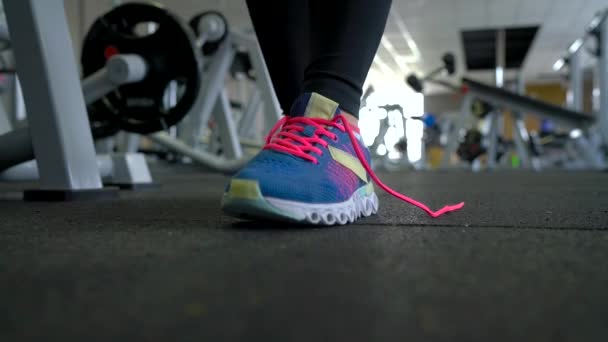 Zapatos de correr - mujer atando cordones de zapatos en el gimnasio — Vídeo de stock