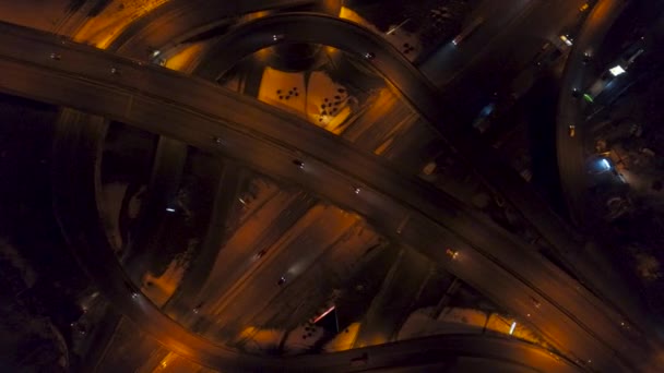 Vertical top down aerial view of traffic on freeway interchange at night — Stock Video