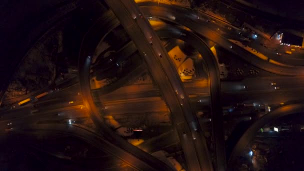 Vertical top down aerial view of traffic on freeway interchange at night — Stock Video