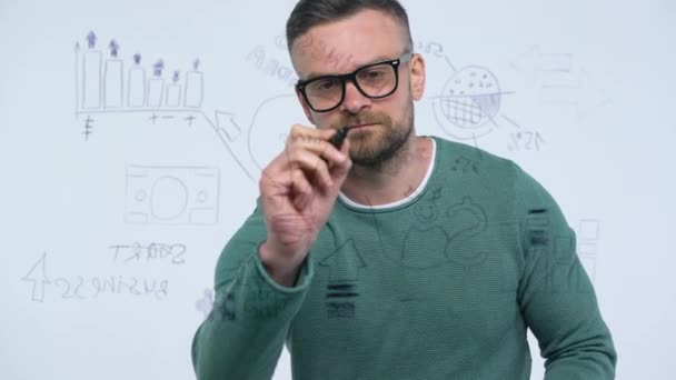 Mann zeichnet verschiedene Wachstumstabellen und berechnet Erfolgsaussichten in einem modernen Glasbüro — Stockvideo