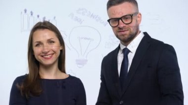Erkek ve kadın el sıkışın ve modern cam ofis başarı için iş stratejisi tartışmak