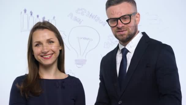 Чоловік і жінка тремтять руками і обговорюють бізнес стратегію успіху в сучасному скляному офісі — стокове відео