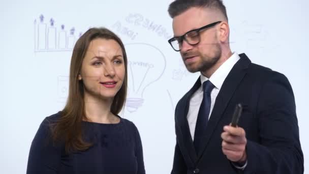 Homme et femme discutent de la stratégie commerciale pour réussir dans un bureau en verre moderne — Video