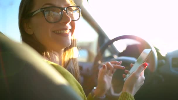 Γυναίκα σε ποτήρια χρησιμοποιώντας ένα smartphone στο αυτοκίνητο — Αρχείο Βίντεο