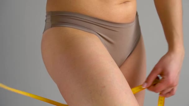 Frau misst ihr Bein mit Maßband — Stockvideo