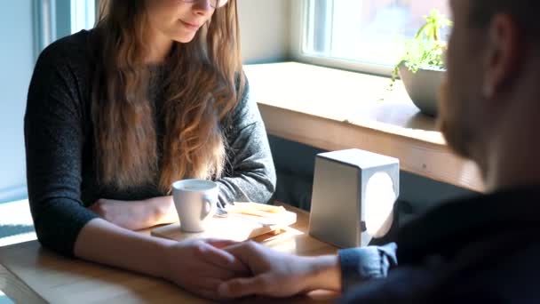 Молодая пара разговаривает и пьет кофе в кафе — стоковое видео