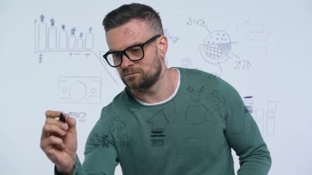 El hombre dibuja varias tablas de crecimiento, calculando las perspectivas de éxito en una moderna oficina de vidrio — Vídeos de Stock