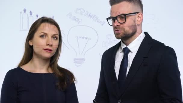 Hombre y mujer discuten la estrategia de negocio para el éxito en una moderna oficina de vidrio — Vídeo de stock