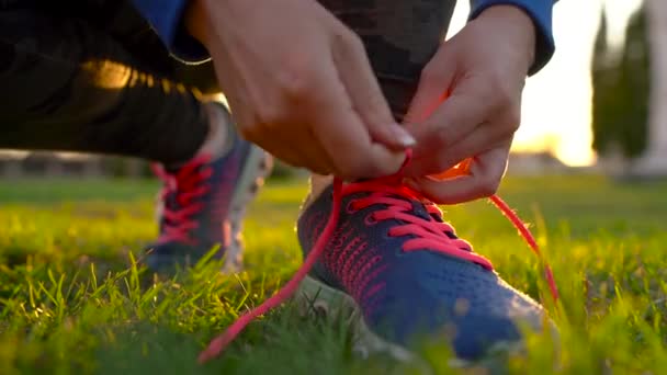 Взуття для бігу - жінка, що зв'язує взуття мереживами. Повільний рух — стокове відео