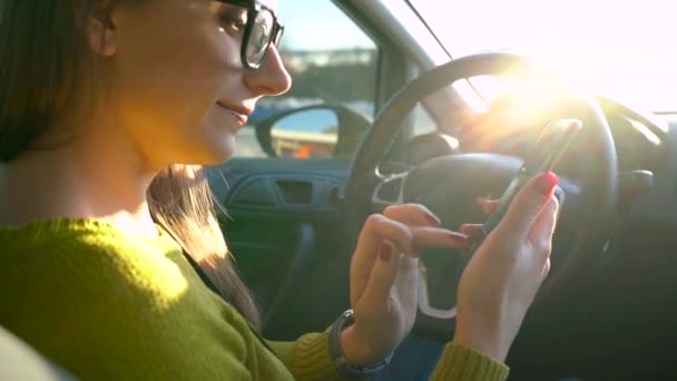 Woman in glasses using a smartphone in the car — Stock Video