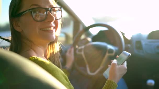 Femme en lunettes à l'aide d'un smartphone dans la voiture — Video