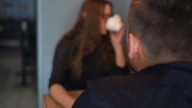 Genç çift kafede konuşuyor ve kahve içiyor.