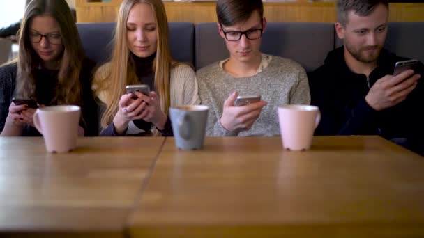 Група людей використовує мобільні телефони в кафе замість спілкування один з одним — стокове відео