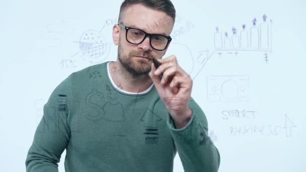 Homem desenha vários gráficos de crescimento, calculando perspectivas de sucesso em um escritório de vidro moderno — Vídeo de Stock