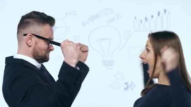 Uomo e donna si rallegrano del successo e si divertono in un moderno ufficio in vetro — Video Stock
