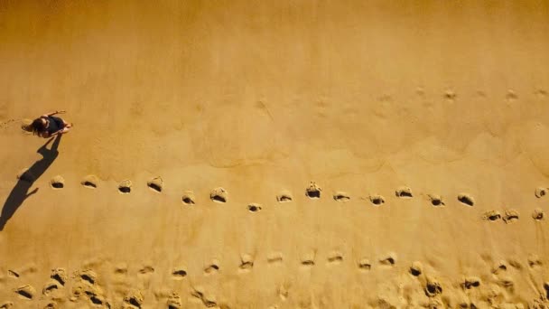 Vista superior de una mujer corriendo descalza a lo largo de la playa de arena húmeda océano — Vídeos de Stock