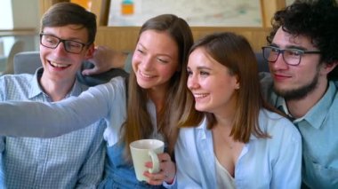 Gülümseyen arkadaşlar bir kafede oturup, iletişim iyi eğlenceler ve selfie yapmak