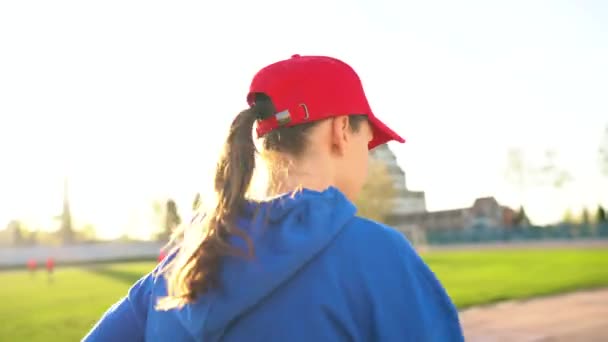 Mulher corre pelo estádio ao pôr-do-sol — Vídeo de Stock
