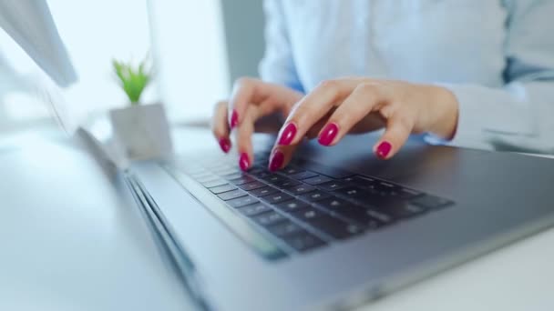 Vrouwelijke handen met heldere manicure typen op een laptop toetsenbord — Stockvideo