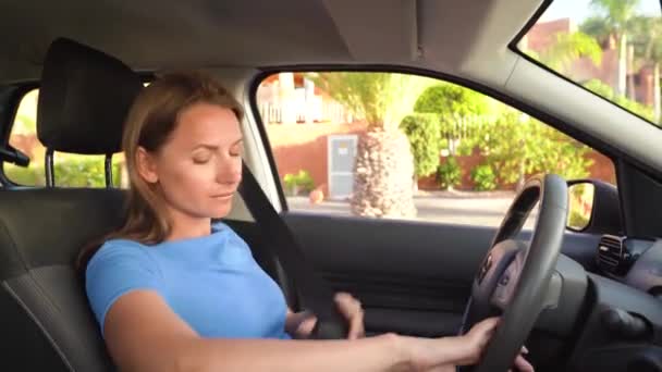Женщина в синем платье пристегивает ремень безопасности автомобиля, сидя внутри автомобиля перед вождением — стоковое видео