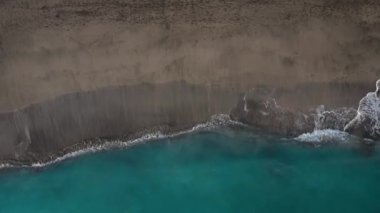 Atlantik Okyanusu'ndaki çöl siyah plajının en iyi manzarası. Tenerife adasının sahili. Kıyıya ulaşan deniz dalgalarının havadan drone görüntüleri