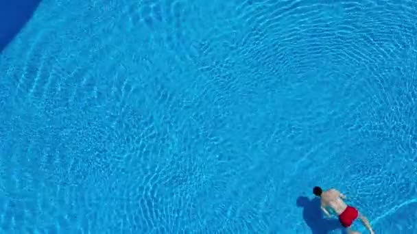 Vista desde arriba mientras un hombre nada bajo el agua en la piscina — Vídeos de Stock