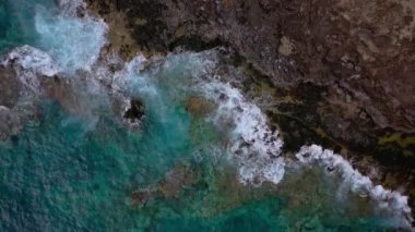 Issız bir sahilin en iyi manzarası. Tenerife adasının kayalık kıyısı. Kıyıya ulaşan okyanus dalgalarının havadan drone görüntüleri