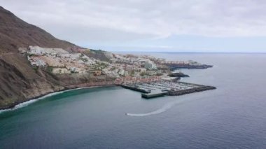 Los Gigantes 'in havadan görünüşü, marina ve şehir manzarası. Tekne marinaya giriyor. Hızlandırılmış video enerjisi, Kanarya Adaları, İspanya
