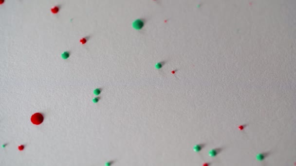 Salpicaduras de pintura de acuarela roja y verde caen sobre una hoja de papel — Vídeos de Stock