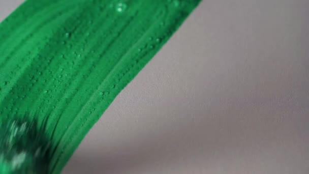 Рисунок кисточкой на белой бумаге с зеленой акварелью экстремально крупным планом. Текстура и фон — стоковое видео