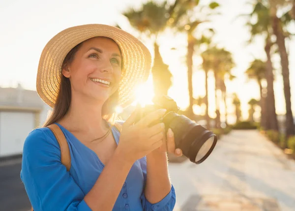 Photographer turis wanita mengambil foto dengan kamera di sebuah beauti Stok Foto Bebas Royalti